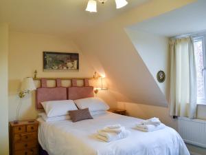 een slaapkamer met een bed met twee handdoeken erop bij Alderley House in Bourton on the Water