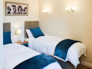 a bedroom with two beds with blue pillows at White Abbey in Kildwick
