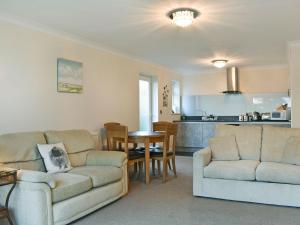 a living room with two couches and a kitchen at Bay View West Wing in Carlyon Bay