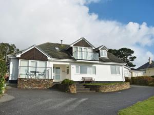 a white house with a porch and a table at Bay View West Wing in Carlyon Bay