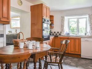 a kitchen with a wooden table and chairs in it at Laurel Farm in Rolstone