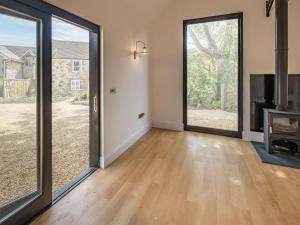 an empty living room with large sliding glass doors at Badgers Sett Brook in Brook