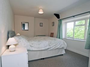 Schlafzimmer mit einem Bett und einem Fenster in der Unterkunft Maxmills Cottage - E1852 in Banwell