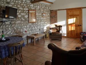 uma sala de estar com uma mesa e uma parede de pedra em Guillemot Cottage em Flamborough