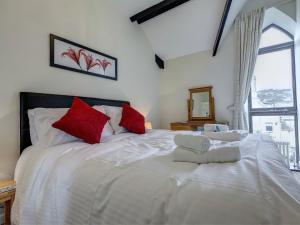a bedroom with a large white bed with red pillows at 6 Torwood Gables in Torquay