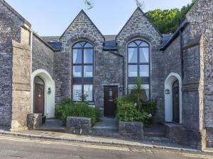 a stone house with arched windows on a street at 6 Torwood Gables in Torquay