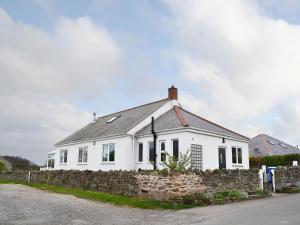 a white house with a stone wall at The Old Parish Hall in Seahouses