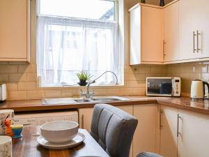 a kitchen with a table and a sink and a window at White Rose Apartment in Bridlington