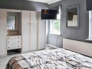 a bedroom with a bed and a tv in it at White Rose Apartment in Bridlington