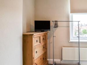 a television on a wooden dresser in a room at White Rose Apartment in Bridlington