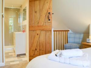 a bedroom with a wooden door and a bed and a chair at The Stable in Bridgwater