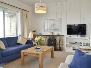 a living room with a blue couch and a table at West Lawn in Rhosneigr