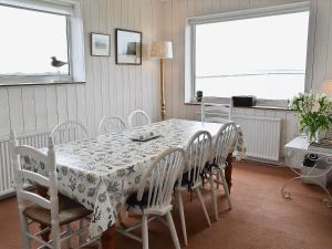 a dining room with a table and white chairs at West Lawn in Rhosneigr