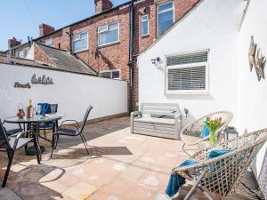 a patio with chairs and a table and a couch at Sea Haven in Woodhorn