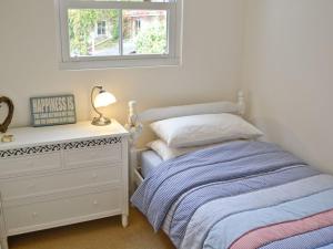 a bedroom with a bed and a dresser and a window at Penny Cottage - Tof in Par