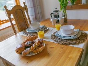 a table with a plate of pastries and cups of orange juice at Teal in Llangennith
