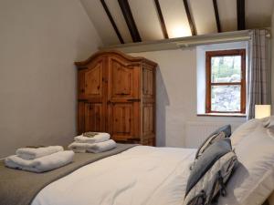 a bedroom with a large bed with towels on it at Teal in Llangennith