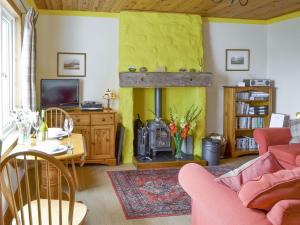 a living room with a fireplace and a tv at Cuillin View in Husabost