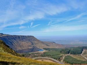 vistas a un valle con un lago en una montaña en The Pig Sty, en Llanfair-ar-y-bryn