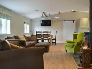 un soggiorno con divano, sedie e tavolo di Waxwing Cottage a Foxton