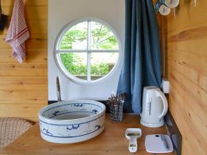 een badkamer met een wastafel en een raam bij Shepherds Rest in Wedmore