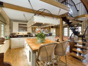 a kitchen with a wooden table and a spiral staircase at Old Reading Room in Osmotherley