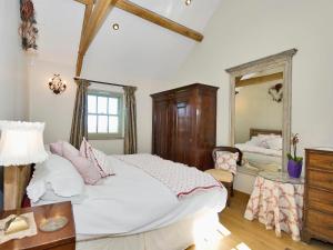 a bedroom with a large bed and a mirror at Old Reading Room in Osmotherley