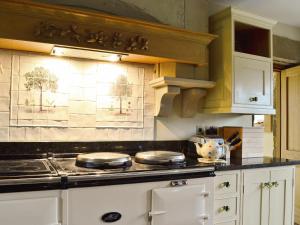 a kitchen with a stove and a counter top at Old Reading Room in Osmotherley