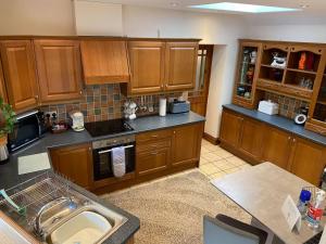 a kitchen with wooden cabinets and a sink at Rivers Edge Cottage in Shotley Bridge