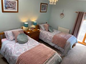 1 dormitorio con 2 camas y ventana en Rivers Edge Cottage, en Shotley Bridge