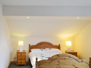 - une chambre avec un lit en bois et 2 lampes dans l'établissement Sealladh Lingeigh, à Pollachar