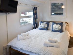 1 dormitorio con 1 cama blanca con almohadas azules y TV en Ludlow Bank en Caulderton