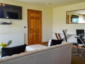 a living room with a couch and a table at Seaviews And Hot Tub At The Fairways - Uk39821 in Portpatrick