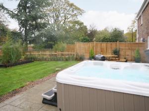 a hot tub in a backyard with a yard at Chestnut Cottage - E5625 in Wainfleet All Saints