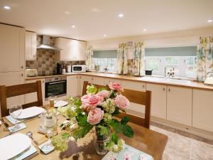 a kitchen with a table with a vase of flowers on it at Chestnut Cottage - E5625 in Wainfleet All Saints