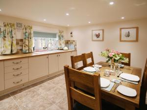 a kitchen with a wooden table with chairs and a dining room at Chestnut Cottage - E5625 in Wainfleet All Saints