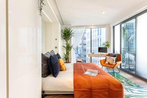 a bedroom with a bed with an orange blanket at Idyllic Covent Garden Flat in London