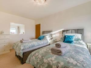 a bedroom with two beds with towels on them at Shawdon Hill Cottage in Glanton