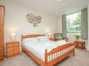 - une chambre avec un grand lit en bois et des draps blancs dans l'établissement Apartment Five - Uk39841, à Paignton