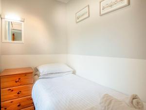 a bedroom with a bed and a dresser and a mirror at Apartment Eleven - Uk39864 in Paignton