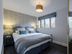 ein Schlafzimmer mit einem großen Bett mit blauen Kissen in der Unterkunft Old Mead House in Folkestone