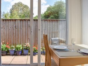 a dining room table with a view of a patio at Ashlea At Amberley in Sidmouth