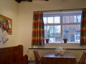 a dining room with a table and a window at Swiss Cottage - E5375 in Alrewas