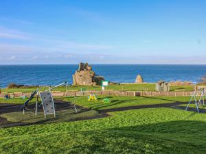 an empty playground with an old castle in the ocean at Mainslea - Uk36872 in Dunure