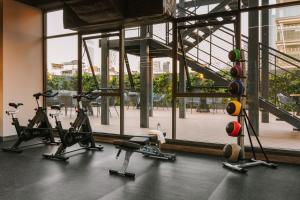 un gimnasio con máquinas de cardio y una gran ventana en Sonder Cielo, en Ciudad de México