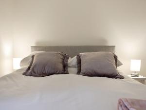 a white bed with two pillows on top of it at Quarry Cottage in Penrith