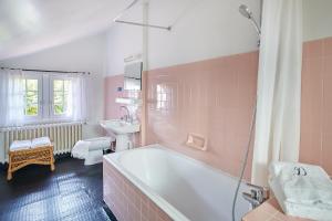 różowa łazienka z wanną i umywalką w obiekcie Maison Dominxenea w Sare