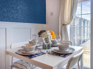 a dining room table with a vase of flowers on it at Seashell House in Burnham on Sea