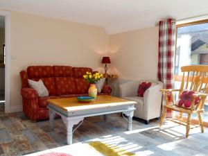 sala de estar con sofá rojo y mesa en Snipelands Barn, en Wedmore
