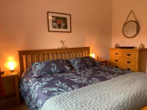 ChillinghamにあるFolly Viewのベッドルーム1室(ベッド1台、ランプ2つ、ドレッサー付)